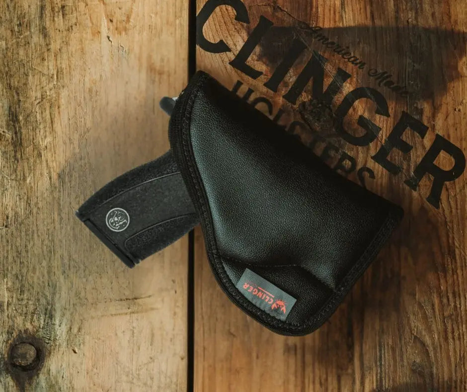 S&W Bodyguard 2.0 in a black Clinger holster on a wooden background